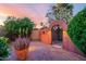 Landscaped backyard with arched entryway and desert plants at 13128 N 104Th Pl, Scottsdale, AZ 85260