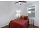 Cozy bedroom with a red comforter, nightstands, and a ceiling fan at 26853 N 176Th Dr, Surprise, AZ 85387