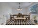 Bright dining area with a wooden table, bench seating, and a stylish chandelier at 26853 N 176Th Dr, Surprise, AZ 85387