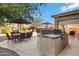 Outdoor kitchen with grill and dining area at 26853 N 176Th Dr, Surprise, AZ 85387