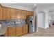 Modern kitchen featuring wood cabinets, granite countertops, and stainless steel appliances at 26853 N 176Th Dr, Surprise, AZ 85387