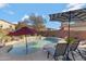 Inviting kidney-shaped pool with patio furniture, umbrellas, and a waterfall feature at 26853 N 176Th Dr, Surprise, AZ 85387