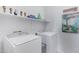 Bright laundry room with washer, dryer, and ample shelf space at 26853 N 176Th Dr, Surprise, AZ 85387