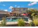 Inviting backyard with a sparkling pool, patio furniture, and umbrellas at 26853 N 176Th Dr, Surprise, AZ 85387