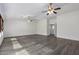 Open living room with wood-look floors and two ceiling fans at 13635 W Calavar Rd, Surprise, AZ 85379