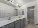 Clean bathroom with double vanity, large mirror, and a separate tub at 13635 W Calavar Rd, Surprise, AZ 85379