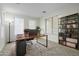 Spacious home office with herringbone floors, large windows, and a built-in bookcase at 13635 W Calavar Rd, Surprise, AZ 85379