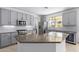 Modern kitchen with granite countertops, stainless steel appliances, and gray cabinets at 13635 W Calavar Rd, Surprise, AZ 85379