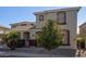 Two-story house with stone and stucco exterior, palm trees, and a landscaped yard at 13635 W Calavar Rd, Surprise, AZ 85379