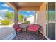 Relaxing covered patio with wicker furniture and desert landscaping at 19620 N Majestic Vista Ct, Surprise, AZ 85387