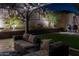 Night view of a backyard patio with seating area and artificial turf at 18518 W Acacia Dr, Goodyear, AZ 85338