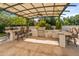 Outdoor kitchen with stainless steel appliances under a pergola at 6717 E Solano Dr, Paradise Valley, AZ 85253