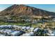 Aerial view of community with golf course, lake, and mountain backdrop at 6154 E Alta Hacienda Dr, Scottsdale, AZ 85251