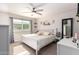 Main bedroom with a white platform bed, ceiling fan, and large window at 907 E 9Th Ave, Mesa, AZ 85204