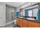 Modern bathroom with double vanity, granite countertop, and glass shower at 10847 E Forge Cir, Mesa, AZ 85208