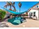Inviting kidney-shaped pool with a teal shade sail and rock waterfall feature at 10847 E Forge Cir, Mesa, AZ 85208