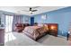 Bright bedroom with a comfortable bed, leather couch, and sliding door access to outdoors at 10847 E Forge Cir, Mesa, AZ 85208