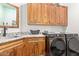 Laundry room with wood cabinets, granite countertop, and washer/dryer at 27808 N Desierto Dr, Rio Verde, AZ 85263