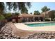Community pool with lounge chairs and a rock pathway at 3119 W Cochise Dr # 106, Phoenix, AZ 85051