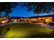 Night view of a backyard with a pool, putting green, and fire pit at 7801 E Davenport Dr, Scottsdale, AZ 85260