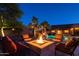 Fire pit surrounded by comfortable seating in a backyard at night at 7801 E Davenport Dr, Scottsdale, AZ 85260