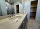 Elegant bathroom with double sinks, marble tile, and walk-in shower at 3812 W Antelope Way, San Tan Valley, AZ 85144