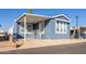 Single-wide manufactured home with covered porch and blue siding at 7750 E Broadway Rd # 723, Mesa, AZ 85208