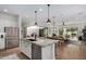 Bright, open kitchen featuring a large island with sink, dining area, and open concept living space at 17197 W Thousand Oaks St, Surprise, AZ 85388