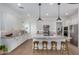 Modern kitchen with granite countertops, white shaker cabinets, stainless steel appliances, and island seating at 17197 W Thousand Oaks St, Surprise, AZ 85388