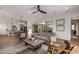 Stylish living room with wood-look tile, plush sofa, coffee table, and open access to the kitchen and dining areas at 17197 W Thousand Oaks St, Surprise, AZ 85388