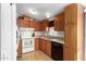 Wood kitchen cabinets, white appliances and a double sink at 3301 S Goldfield Rd # 1009, Apache Junction, AZ 85119