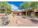 Desert landscape with a Spanish-style home, featuring a large garage and brick driveway at 27440 N Alma School Pkwy # 33-1, Scottsdale, AZ 85262