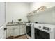 Laundry room with washer, dryer, granite countertop, and built-in shelving at 17197 W Thousand Oaks St, Surprise, AZ 85388