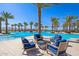Seating area near a large resort-style pool with palm trees at 17197 W Thousand Oaks St, Surprise, AZ 85388