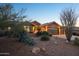 View of a tan house with a double garage and desert landscaping at 11255 S San Adrian Ln, Goodyear, AZ 85338