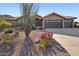 Single story home with desert landscaping and a two car garage at 11255 S San Adrian Ln, Goodyear, AZ 85338