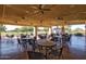 Spacious covered patio with multiple tables and chairs, overlooking a golf course at 11544 W Javelina Ct, Surprise, AZ 85378