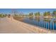 Peaceful lakeside walkway with a brick and metal fence at 45680 W Barbara Ln, Maricopa, AZ 85139