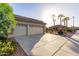 Three-car garage with a long driveway and desert landscaping at 16513 W Windsor Ave, Goodyear, AZ 85395