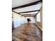 Living room with wood-look flooring, exposed beams, and large window at 4936 E Coronado Rd, Phoenix, AZ 85008