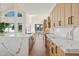 Modern kitchen with marble countertops and light wood cabinets at 8133 E Cortez Dr, Scottsdale, AZ 85260