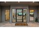 Modern front entrance with glass doors and a stylish doormat, welcoming guests into the home at 10119 E Horizon Dr, Scottsdale, AZ 85262