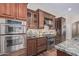 Well-equipped kitchen with double ovens, gas cooktop, and granite countertops at 2717 W Nighthawk Way, Phoenix, AZ 85045
