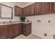 Laundry room with wooden cabinets and a utility sink at 2717 W Nighthawk Way, Phoenix, AZ 85045