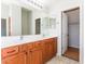 Bathroom with double sinks, wood cabinets, and a shower at 34831 N Mashona Trl, San Tan Valley, AZ 85143