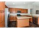 Modern kitchen with wood cabinets, stainless steel appliances and an island at 34831 N Mashona Trl, San Tan Valley, AZ 85143