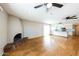 Living room with hardwood floors, brick fireplace, and kitchen access at 4903 W Desert Cove Ave, Glendale, AZ 85304