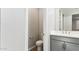 Modern powder room with gray vanity and updated fixtures at 5827 E Rose Garden Ln, Phoenix, AZ 85054