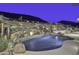 Night view of a luxurious backyard pool and waterfall feature at 5516 W Melinda Ln, Glendale, AZ 85308