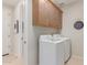 Laundry room with washer, dryer, and overhead cabinets at 18191 W Cielo Grande Ave, Surprise, AZ 85387